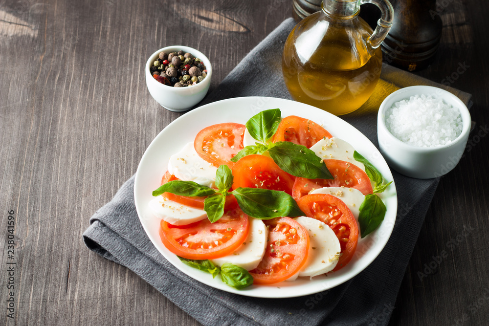 Close-up photo of caprese salad with ripe tomatoes, basil, buffalo mozzarella cheese. Italian and Mediterranean food concept. Fresh and healthy organic meal. Starter and antipasti. Close-up photo of caprese salad with ripe tomatoes, basil, buffalo mozzarella cheese. Italian and Mediterranean food concept. Fresh and healthy organic meal. Starter and antipasti.