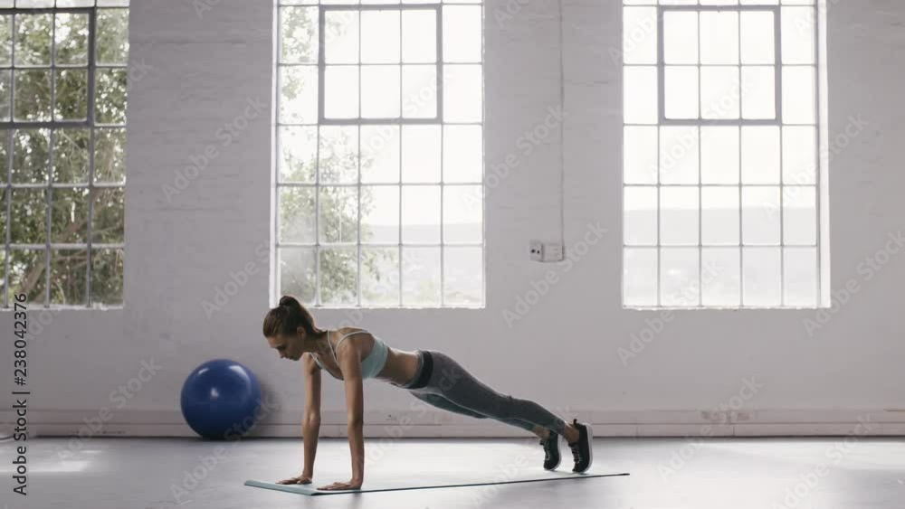 Fitness woman doing push up holds at gym. Female in sportswear doing push-up holds at fitness studio. Fitness woman doing push up holds at gym. Female in sportswear doing push-up holds at fitness studio.