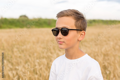 boy in wheat field. child. wheat field. boy with sunglasses