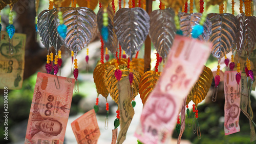 Fotografija Closeup of Thai baht donation money and metallic leaf decoration inside a Thai temple