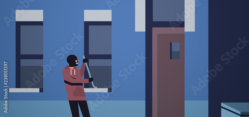 burglar in black mask using crowbar breaking entering into home criminal thief character trying to force window night city building exterior flat horizontal