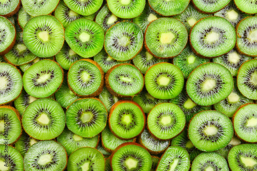 Top view of heap of sliced kiwi as textured background.