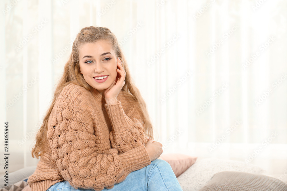 Attractive young woman in cozy warm sweater at home. Space for text Attractive young woman in cozy warm sweater at home. Space for text