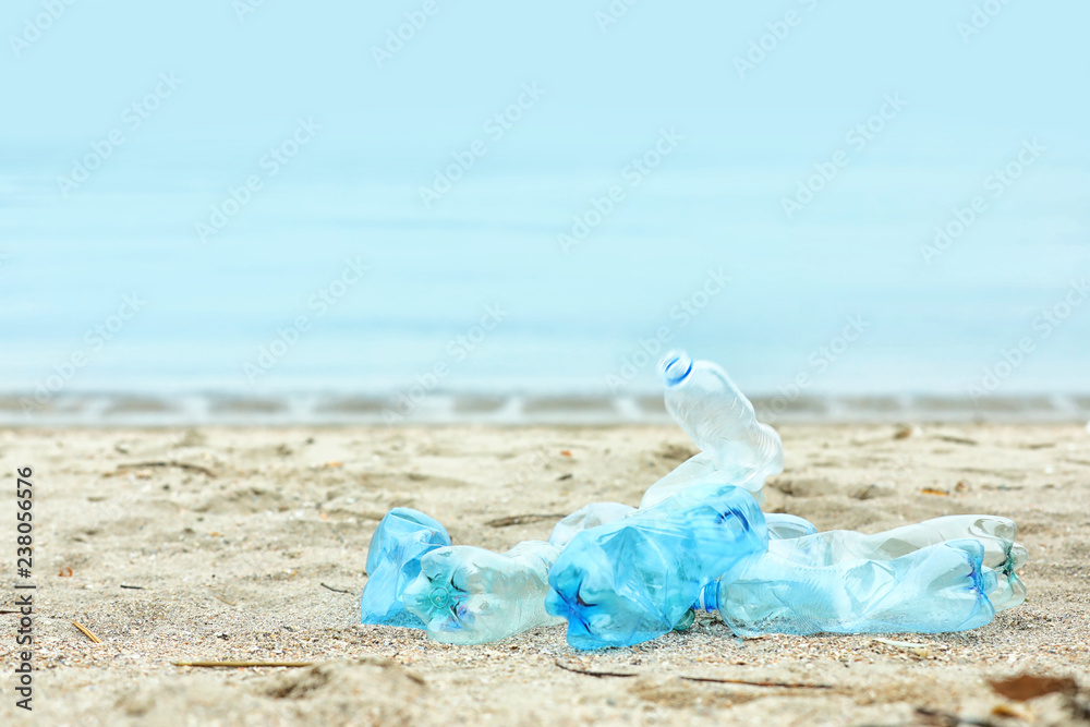 Used plastic bottles on beach, space for text. Recycling problem Used plastic bottles on beach, space for text. Recycling problem