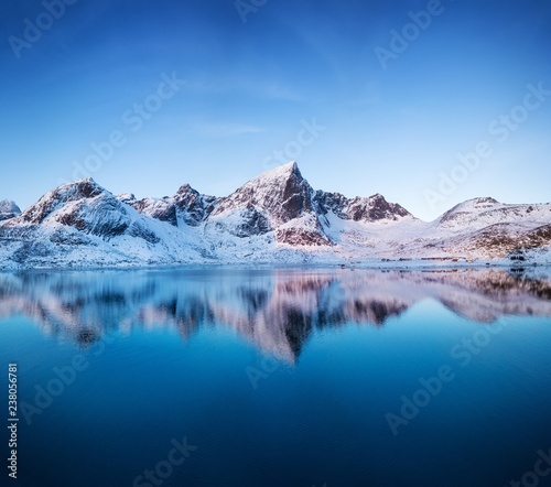 Aerial view at the mountains and reflection on the water surface. Lofoten islands, Norway. Natural landscape during sunrise from air. Drone landscape
