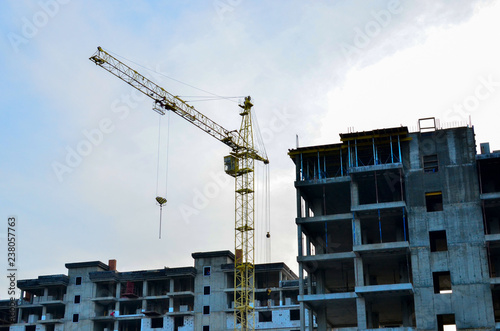 Building construction site with crane against bright blue sky. Construction of new high-rise from concrette and steel. photo