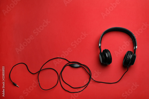 Stylish modern headphones with earmuffs on color background, top view. Space for text