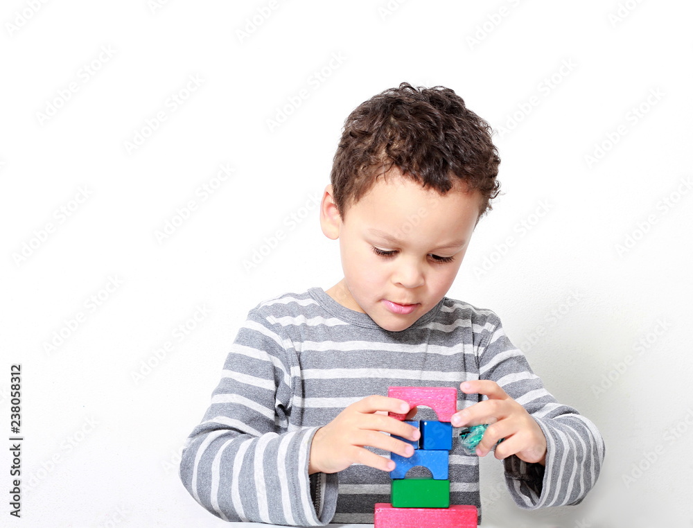 little boy testing his creativity by building towers with toy building blocks little boy testing his creativity by building towers with toy building blocks