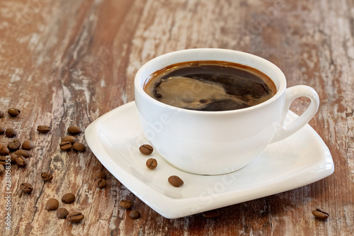 Black coffee in a cup on a wooden background