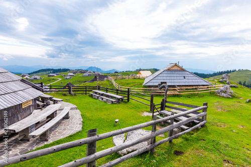 Slovenia velika planina (big plateau), agriculture pasture land near city Kamnik in Slovenian Alps. Wooden houses on green land used by herdsmen. Mountain village with big pasture plateau. photo