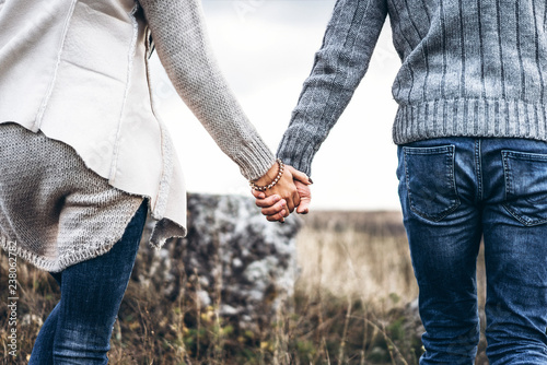 Photo of romatic couple hands, walking outdoor and spending time together.