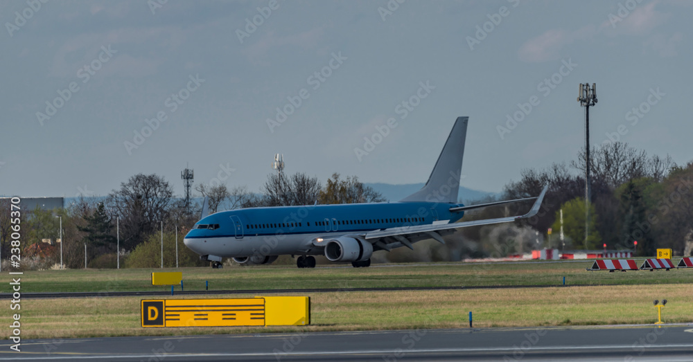Fototapeta premium Landing of blue and white airplane in capital Prague