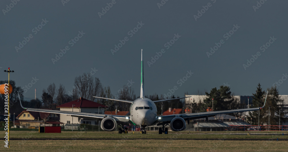 Fototapeta premium Front view of landing of white airplane in capital Prague