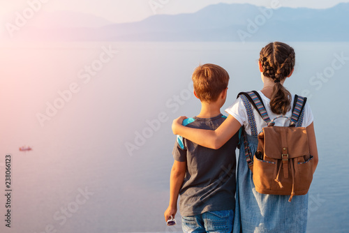 Young beautiful girl with her younger brother traveling along the coast of the Mediterranean Sea. photo