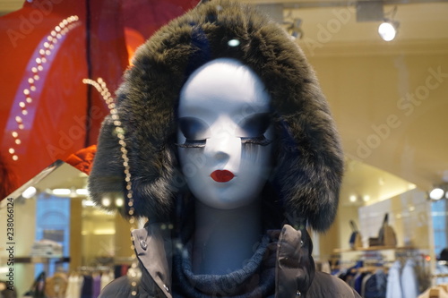 Mannequin's head in a  grey fur hood enormous eyelashes and red lips