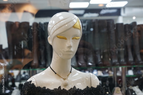 Mannequin's white head with golden eyelashes, hair and  and details of neckless