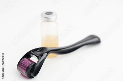 Dermaroller needle with serum in glass bottle. Anti wrinkle skin care. photo