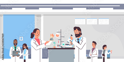 group scientists working with microscope in laboratory doing research man woman making scientific experiments mix race doctors in lab interior portrait workplace horizontal