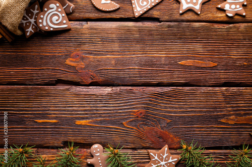 Gingerbread Christmas cookies and spruce tree on wooden background