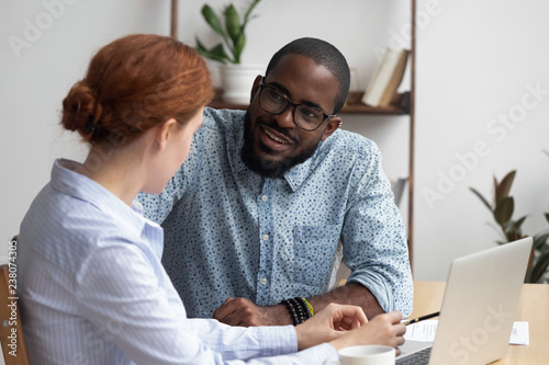 Diverse workmates take break during workday talking have pleasant conversation feels amity interest to each other. Multiracial businesspeople negotiating in relaxed atmosphere solve business issues