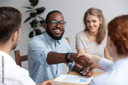 Bild auf Leinwand Diverse businesspeople during seminar, black business trainer greeting female co