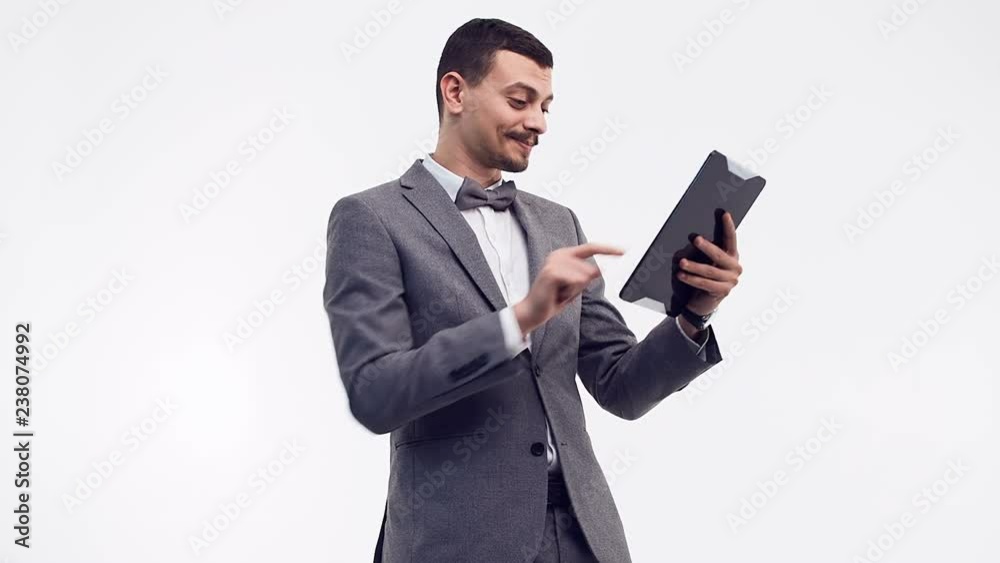 Portrait of handsome young confident arabic doctor with fancy mustache in blue holds tablet isolated on white studio background Portrait of handsome young confident arabic doctor with fancy mustache in blue holds tablet isolated on white studio background
