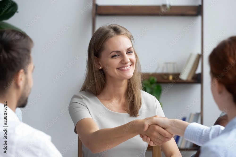 Attractive new employee newcomer shaking hands getting acquainted with staff during meeting. Coach greeting company owner starting training, investor and representative handshaking before negotiating Attractive new employee newcomer shaking hands getting acquainted with staff during meeting. Coach greeting company owner starting training, investor and representative handshaking before negotiating
