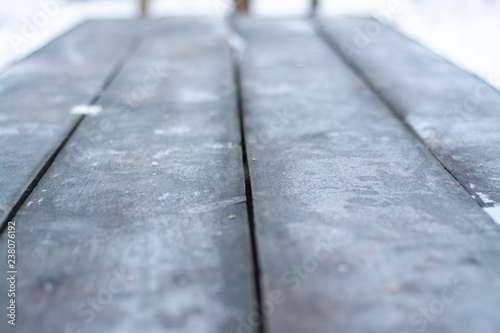 Tabletop wooden table with hoarfrost outdoors in winter