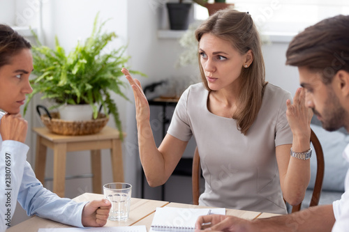 Dissatisfied team leader talking with colleagues discussing failure in work,  coworkers having different opinion sitting together in office arguing disputing blond colleague insists on her point o photo