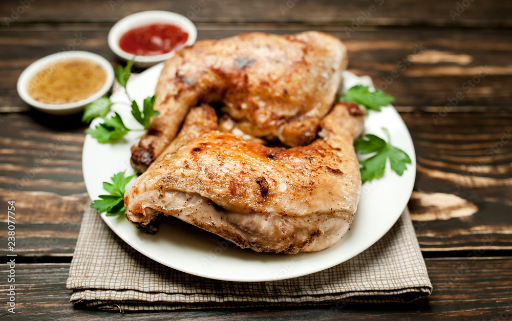 Chicken legs in a plate with mustard and ketchup on a wooden background. Chicken legs in a plate with mustard and ketchup on a wooden background.