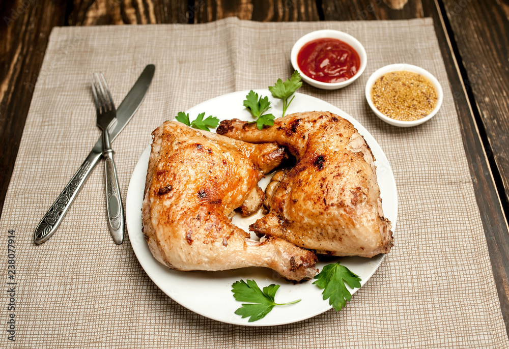 Chicken legs in a plate with mustard and ketchup on a wooden background. Chicken legs in a plate with mustard and ketchup on a wooden background.