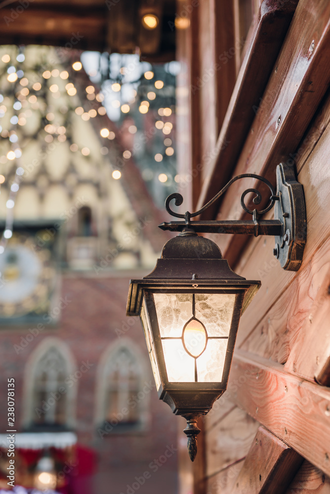 Christmas Festive illumination lantern on a building. Lights background. Festive illumination on a wooden house.