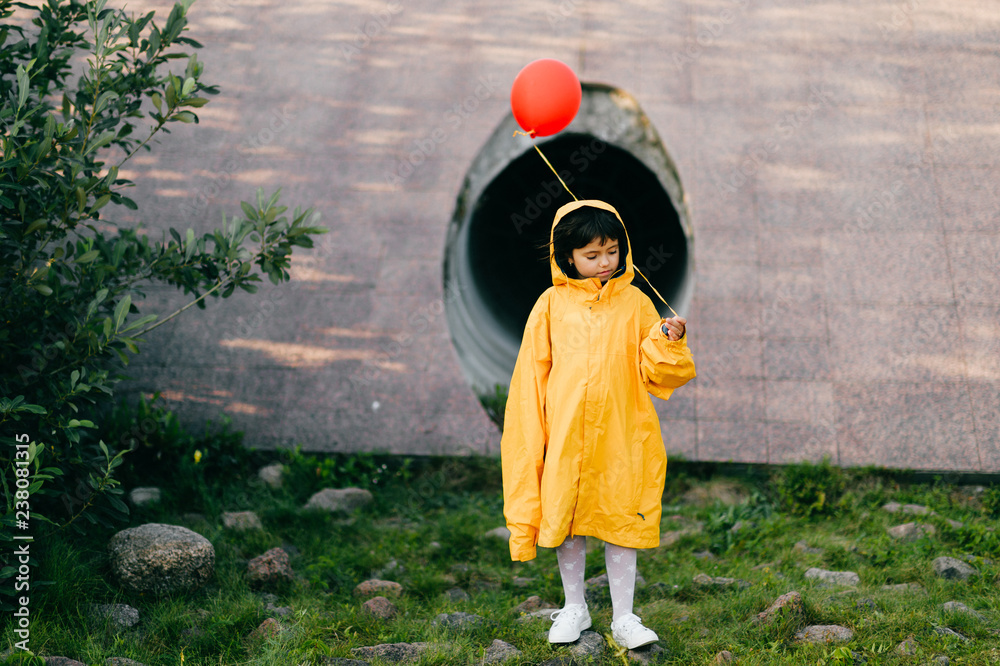Portrait of pretty litle girl in big adult oversized yellow