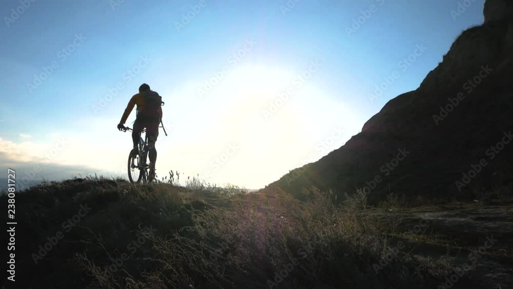 Young male bicycle rider travel on the hills in summer sunny day Young male bicycle rider travel on the hills in summer sunny day
