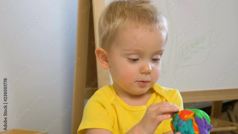 A two years old preschool child making figures from modeling clay (compound). Early childhood education to children concept A two years old preschool child making figures from modeling clay (compound). Early childhood education to children concept