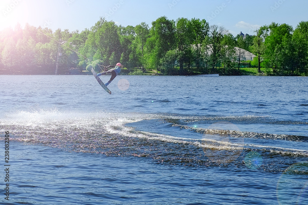 Fototapeta premium Athlete wakeboarder performs a jump with a somersault in the air