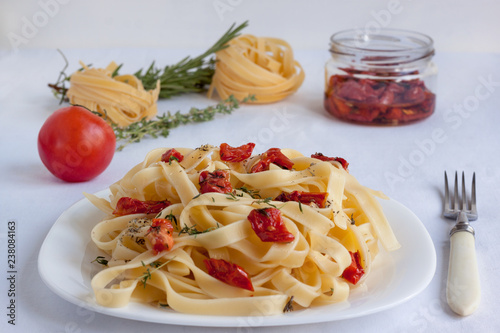 Fettuccine pasta with sun-dried tomatoes and various herbs.