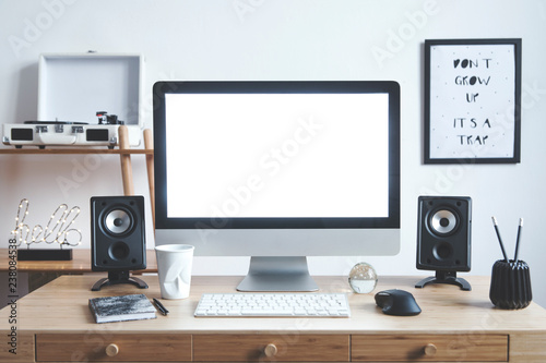 White scandinavian interior of home creative desk with mock up computer screen, photo frame, speakers, office accessories and gramophone. Minimalistic space for work, hobby and listen music.  photo