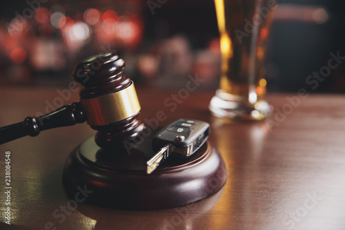 Closeup of a judges gavel and the keys to the car over the soundboard on a dark background