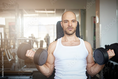 Man training with dumbbell workout in the gym