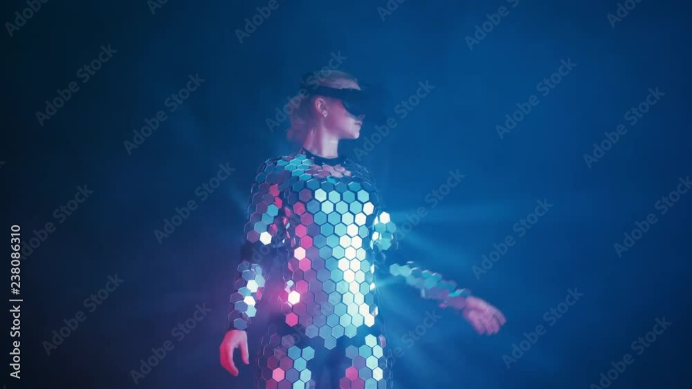 Beautiful young blond female playing game in vr glasses wearing futuristic mirror suit. Beautiful woman touch something using modern virtual reality glasses. Future concept. Beautiful young blond female playing game in vr glasses wearing futuristic mirror suit. Beautiful woman touch something using modern virtual reality glasses. Future concept.