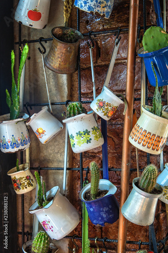 Close up of a bunch of different coffee cezve pots hanged up as a decoration in a cafe