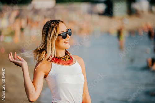 Woman in sunglasses laughing while resting at beach
