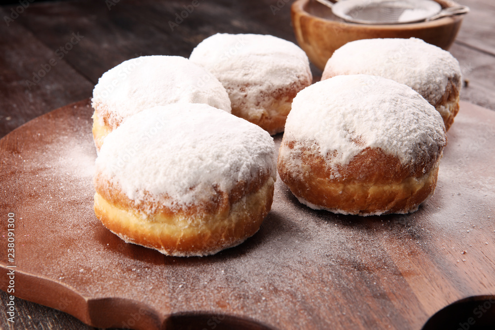 Fototapeta premium German donuts with jam and icing sugar. Carnival powdered sugar raised donuts
