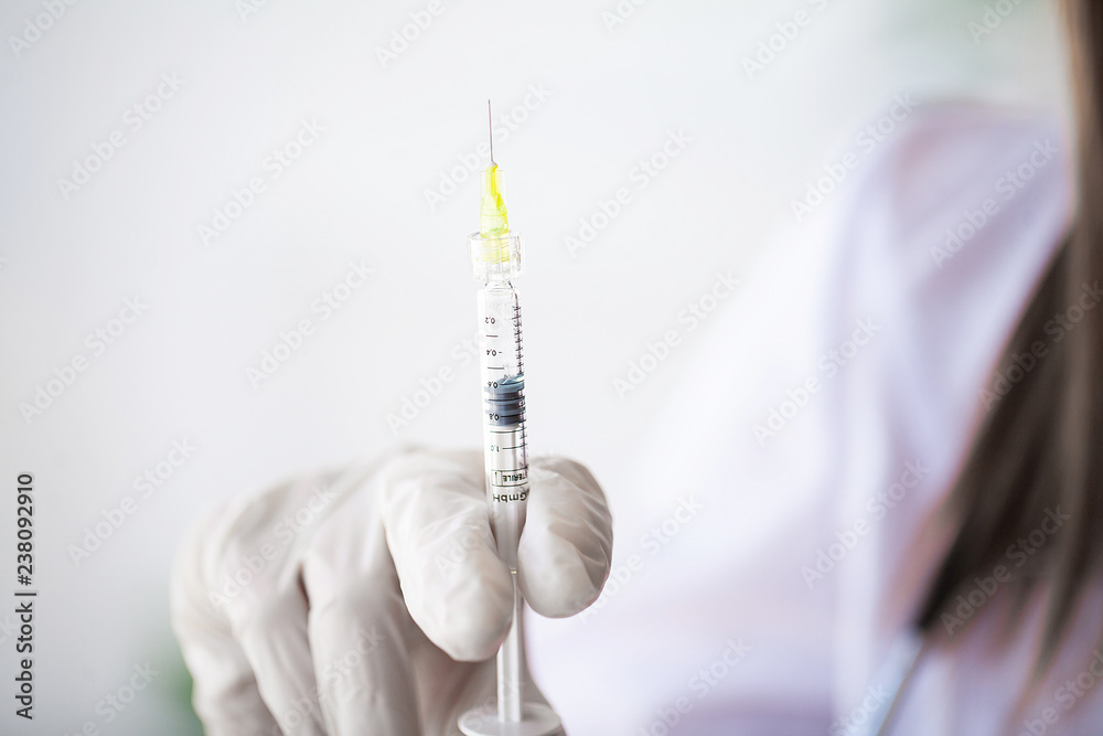 Female doctor or physician holding hypodermic syringe with injection Female doctor or physician holding hypodermic syringe with injection