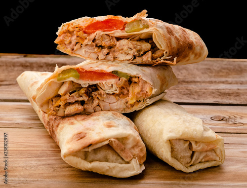 Shawarma sandwich gyro fresh roll of lavash pita bread chicken beef shawarma falafel RecipeTin Eatsfilled with grilled meat, mushrooms, cheese. Traditional Middle Eastern snack. On wooden background photo