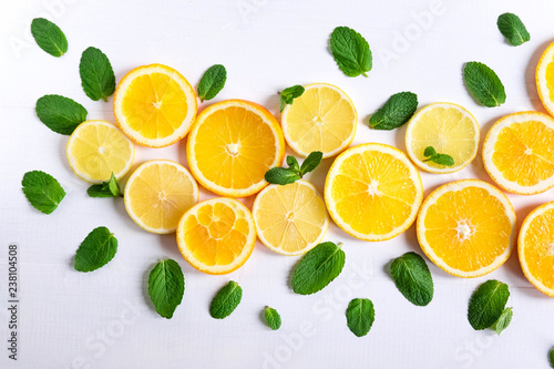 White background with lemon, orange slices and mint. Concept with fresh fruit. Lemon, Orange, Mint. View from above.