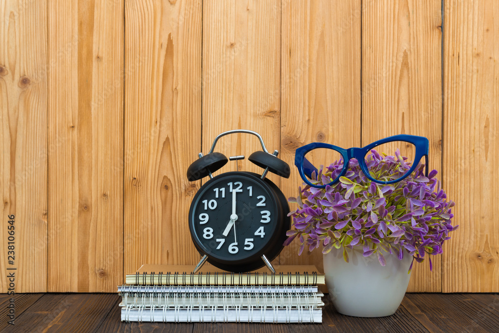 Office supplies tools items, notebook and alarm clock with little tree and glasses on the wood. Office supplies tools items, notebook and alarm clock with little tree and glasses on the wood.