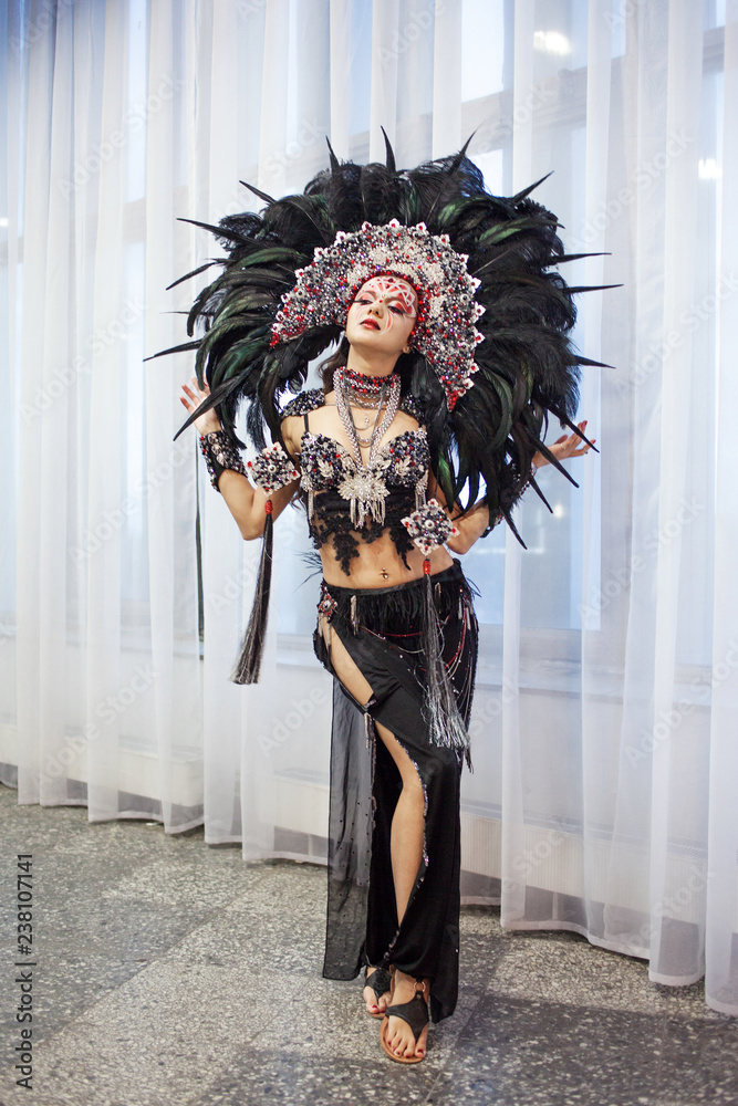Portrait of a young beautiful woman in a creative look. The style of carnival and dancing.