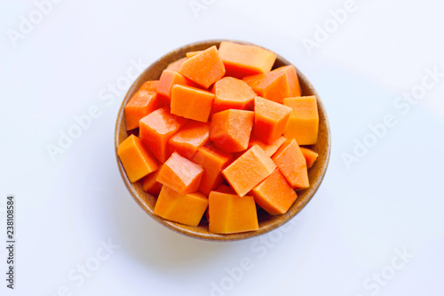 Papaya in wooden bowl on white